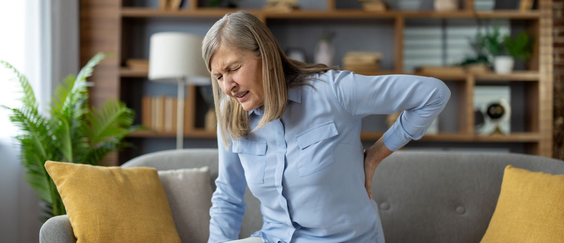 Elderly woman with back pain at home