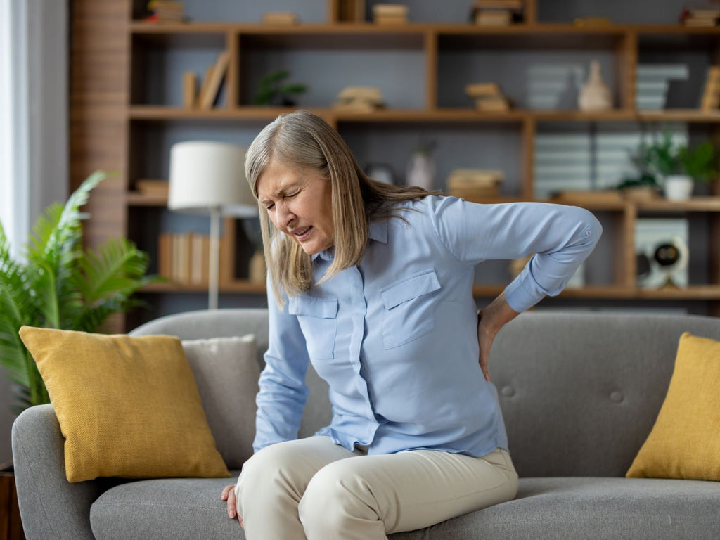 Elderly woman with back pain at home
