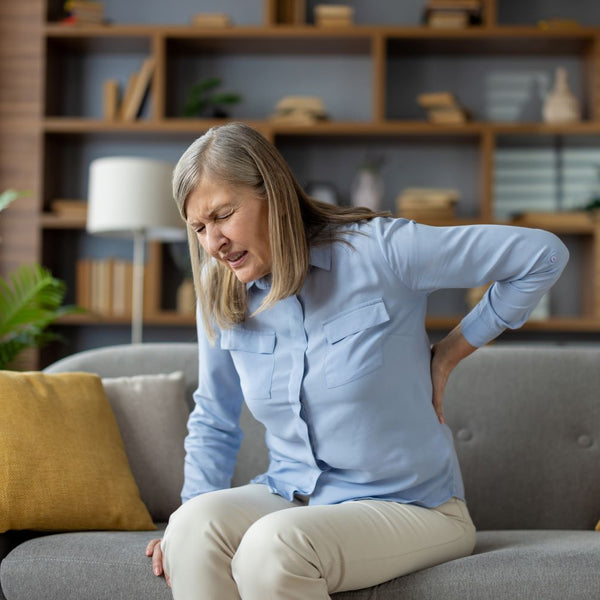 Elderly woman with back pain at home