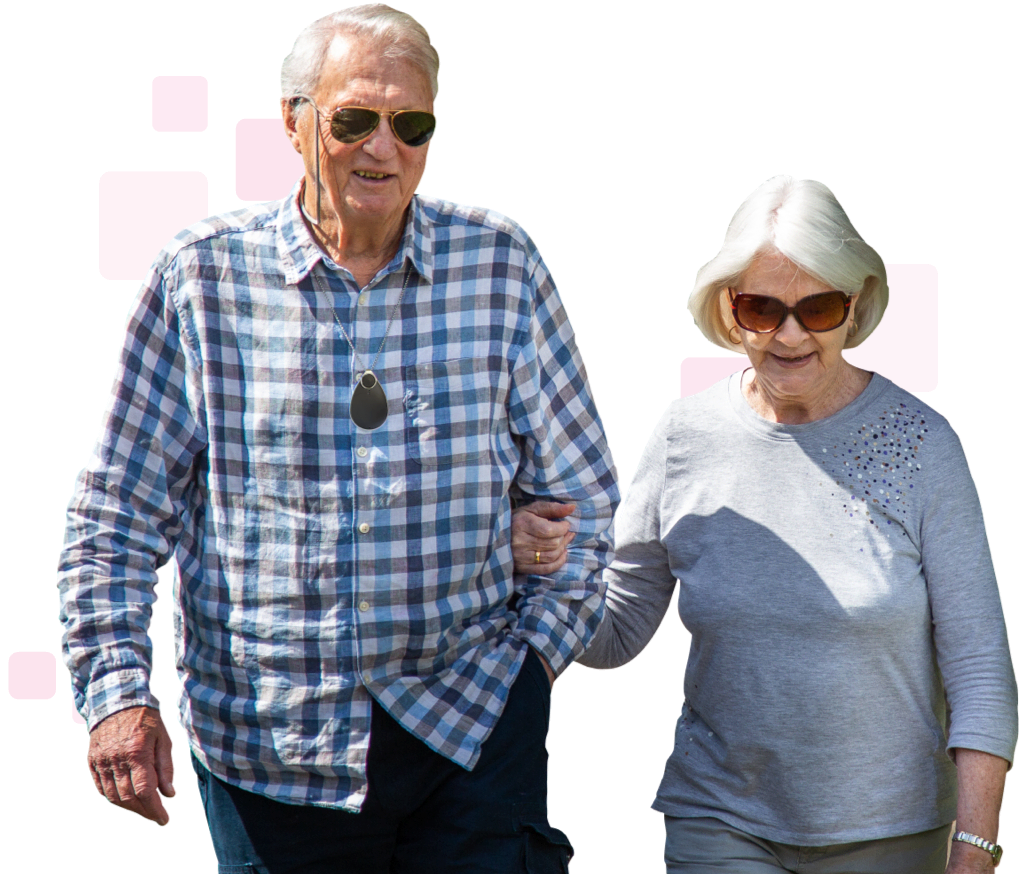 Elderly couple walking together and wearing personal alarms