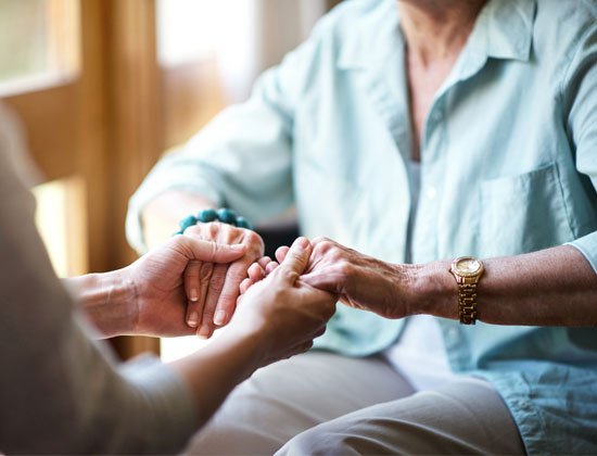 Elderly lady being helped to stand