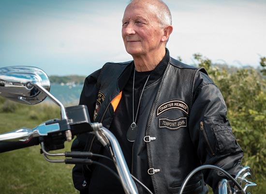 Elderly man in leather jacket with GPS pendant
