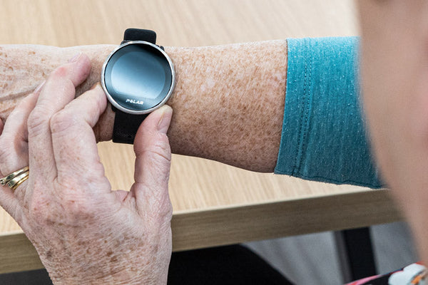 Person wearing a smartwatch on their wrist with a blurred background