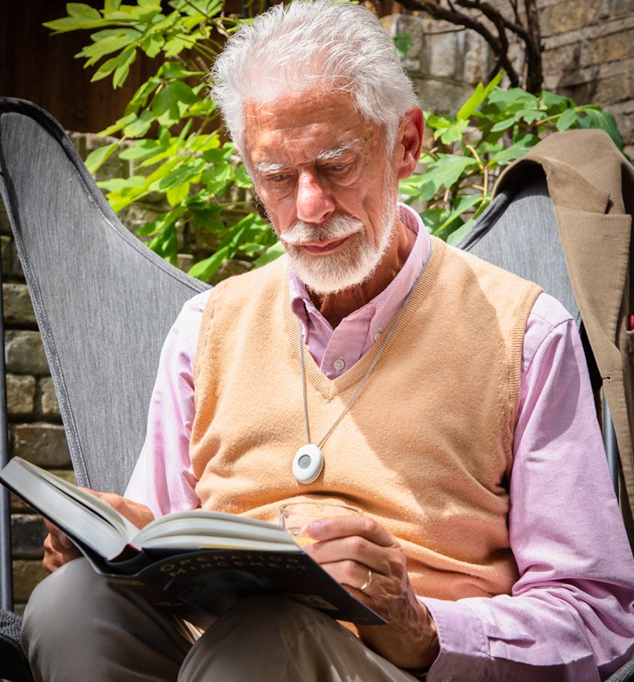 Elderly gentlemen outside wearing a personal alarm