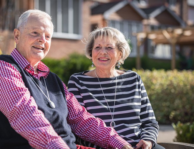 Senior couple sitting outdoors with a blurred background