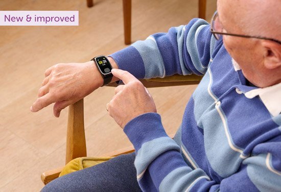 Person wearing a personal alarm watch with text 'New & improved' at the top.
