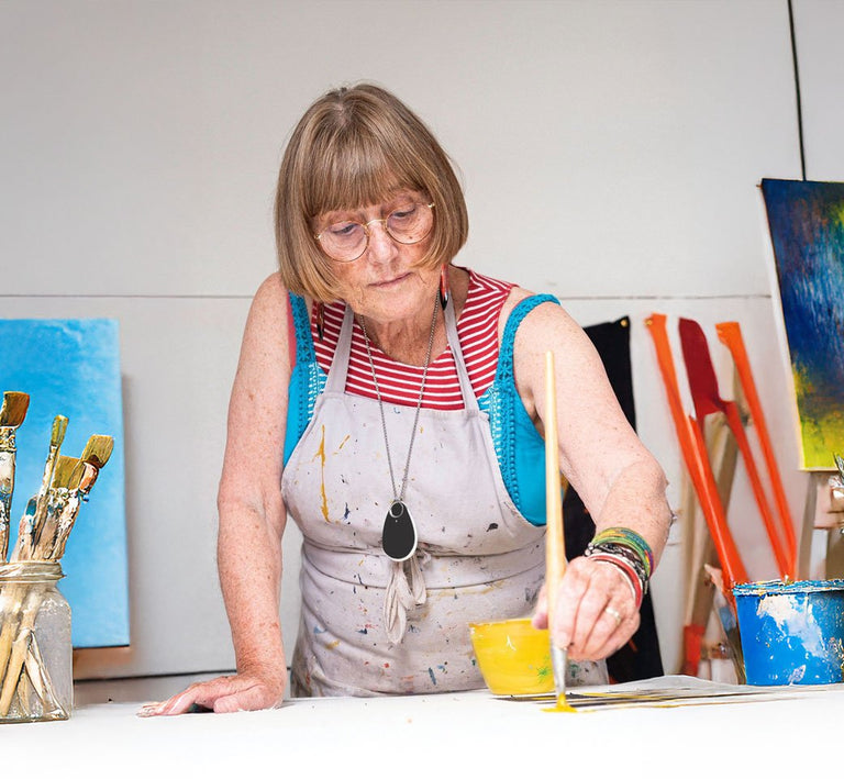Woman in an apron working with art supplies in a studio setting