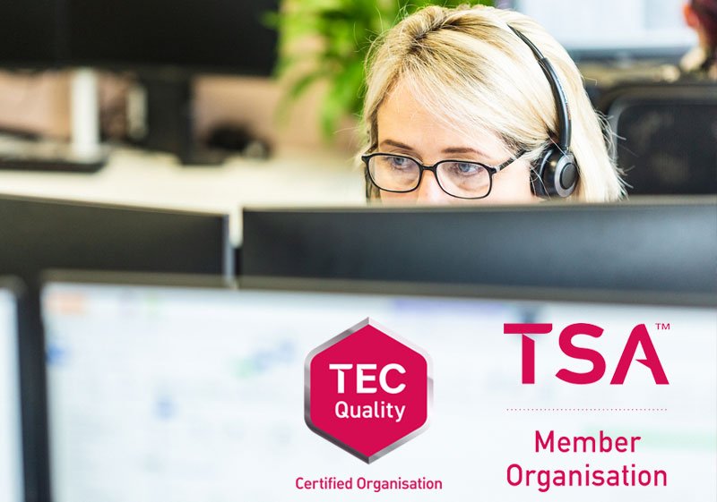 Person wearing a headset in an office setting with TSA and TEC Quality logos.
