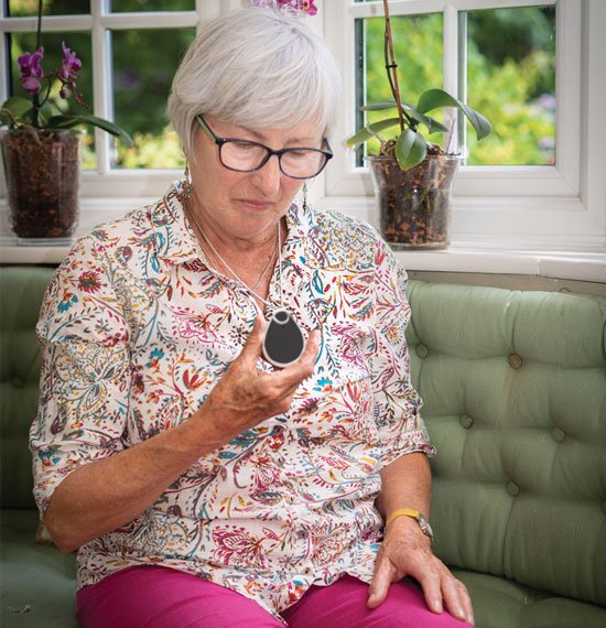 Older lady looking at neck worn pendant alarm