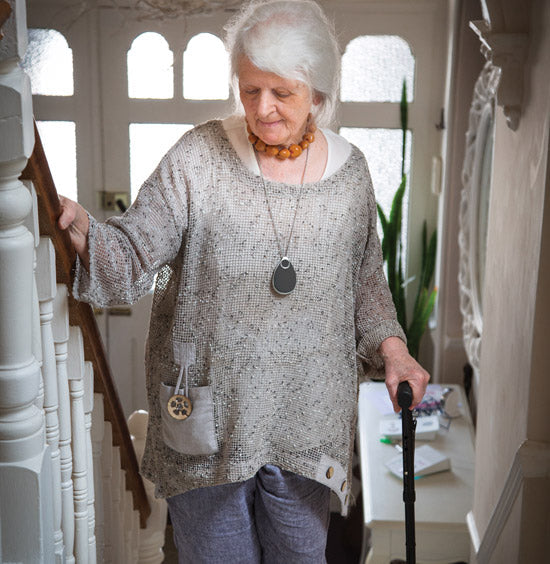 Senior person on stairs with necklace alarm pendant
