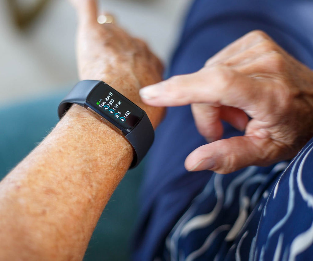 Person using a fitness tracker on their wrist with a blurred background