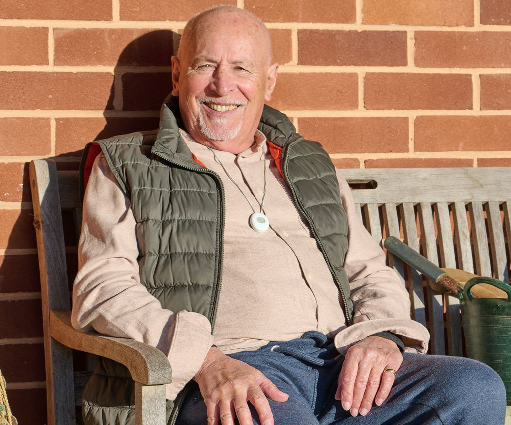 Man sitting on a wooden bench in front of a brick wall