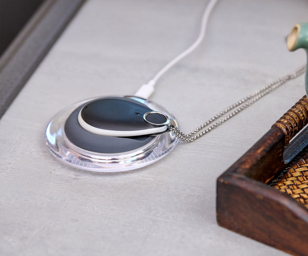 Close-up of a necklace with a pendant alarm on a textured surface