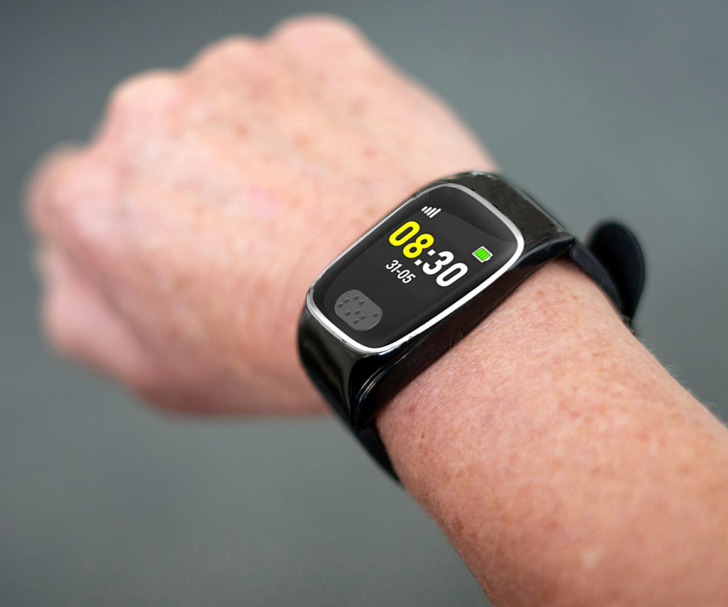 Personal alarm watch on a wrist with a blurred background