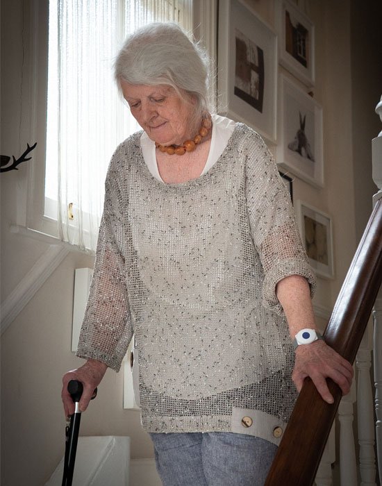 Elderly lady carefully walking down the stairs