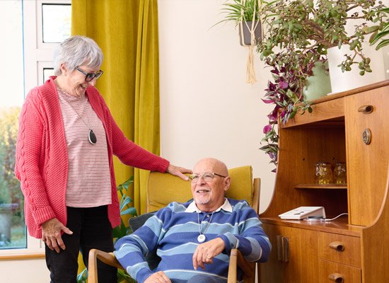 Elderly couple wearing call buttons