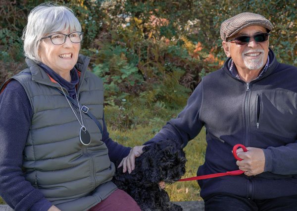 Elderly couple walking the dog wearing an alarm