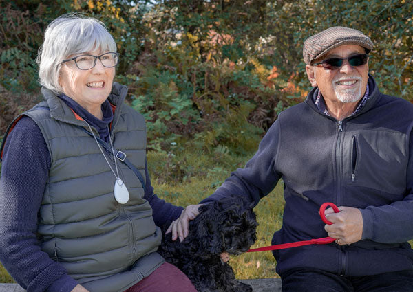 Elderly couple with neck worn GPS pendant